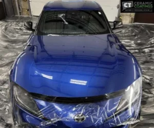 showing clear paint protection film being meticulously applied over the front bumper and emblem, as seen in paint protection film